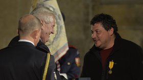 Sedláček ve fleecové mikině za pětistovku přebírá od prezidenta medaili Za zásluhy.