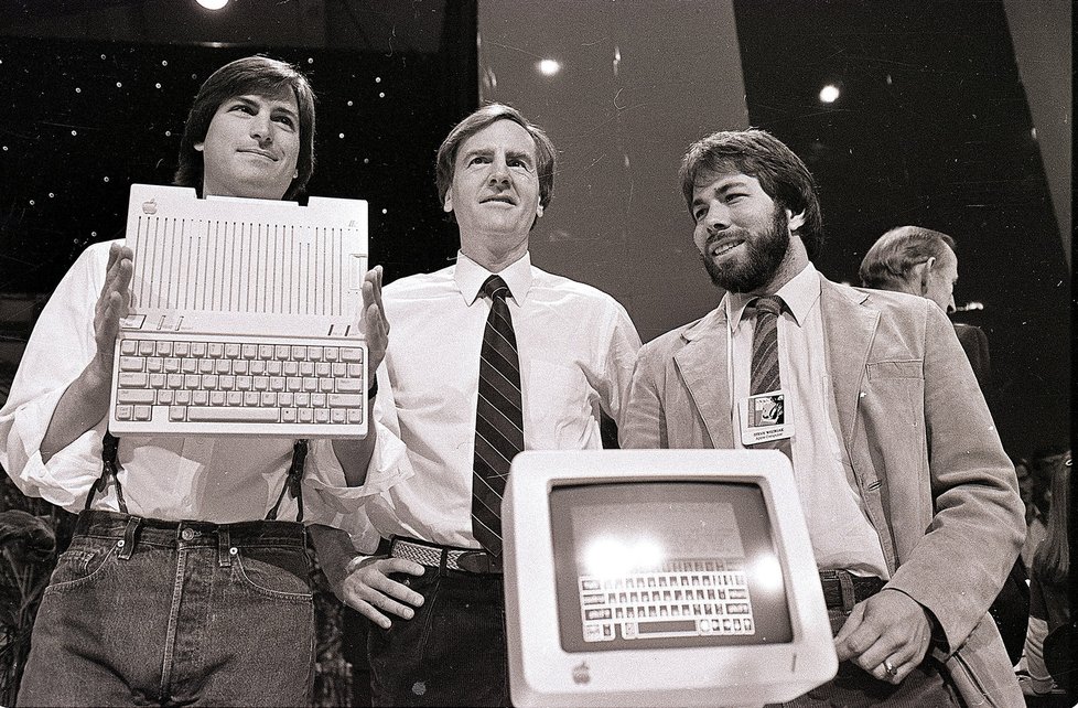 Steve Jobs (vlevo), John Scully (uprostřed) a Steve Wozniak (vpravo) představují Apple IIc.