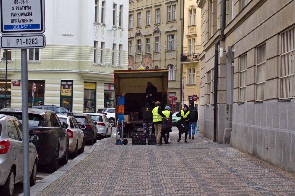 Přepravky naplněné pietními předměty nosili dobrovolníci do dodávky zaparkované za budovou Filozofické fakulty, 15. 1. 2024.