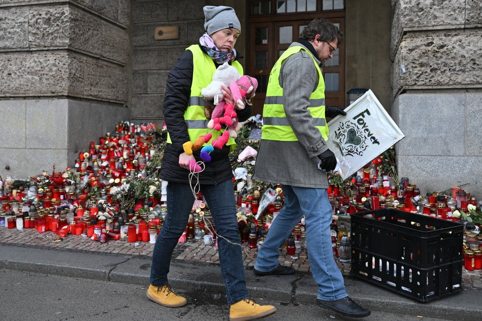Dobrovolníci sbírají a ukládají svíčky a květiny z pietního místa u hlavní budovy Filozofické fakulty Univerzity Karlovy, 15. ledna 2024, Praha.