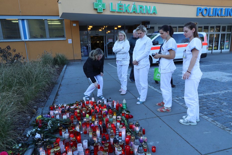 Sestřičky z ostravské nemocnice zapalují na pietním místě svíčky za oběti střelby.