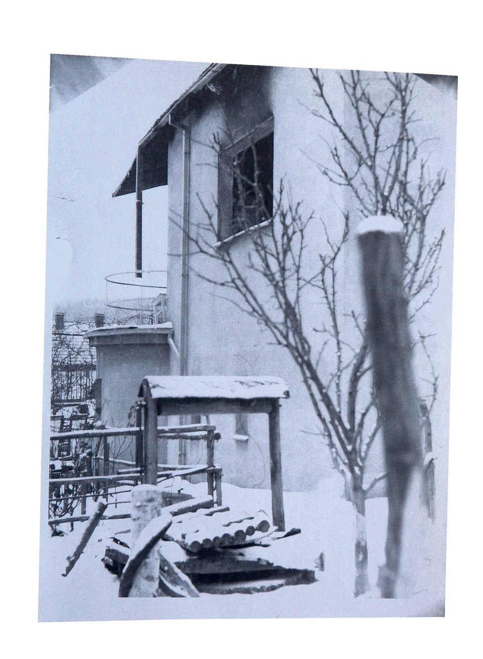 Fotografie vyhořelého domu pořídil kdosi z příbuzných den po vraždě. Poprvé ukazují poničené stromy a skutečnou studnu
