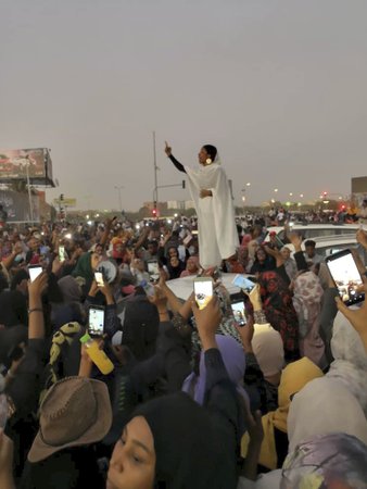 Snímek, který se stal symbolem súdánských protestů. Dvaadvacetiletá dívka stojí na autě a zpívá súdánské revoluční písně.