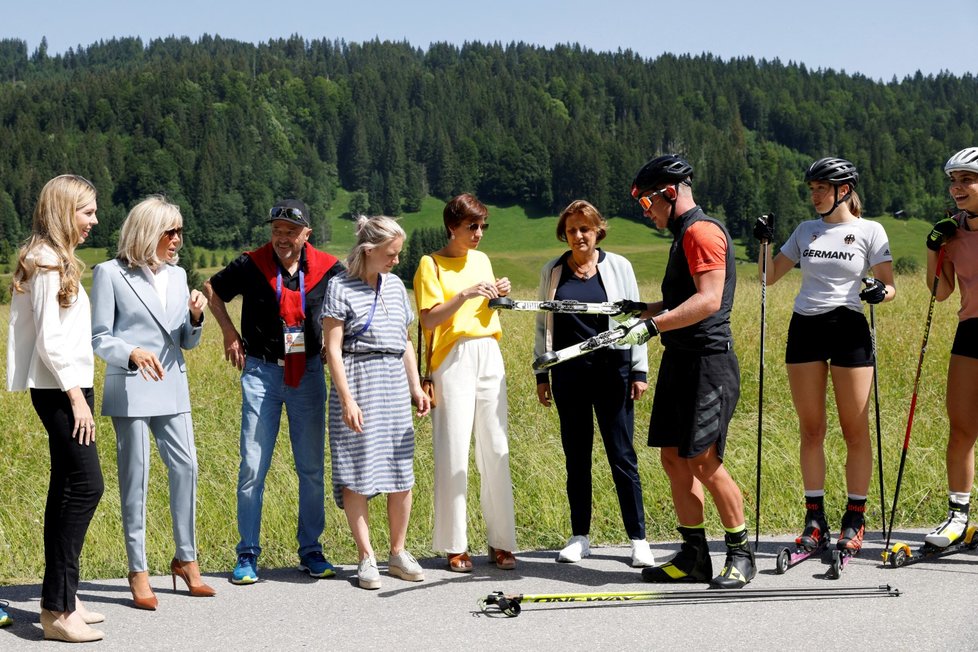 Zleva Carrie Jonsonová, Brigitte Macronová, Amelie Derbaudrenghienová, Britta Ernstová a biatlonisté. (Summit G7, 27. 6. 2022)