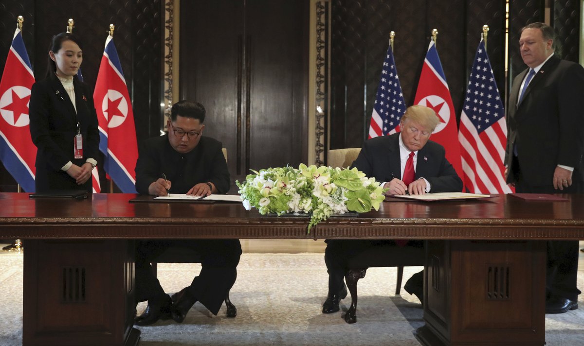 Kim Čong-unovi během podpisu smlouvy asistoval jeho mladší sestra Kim Jo-čong. Trumpovi ministr zahraničí Mike Pompeo.