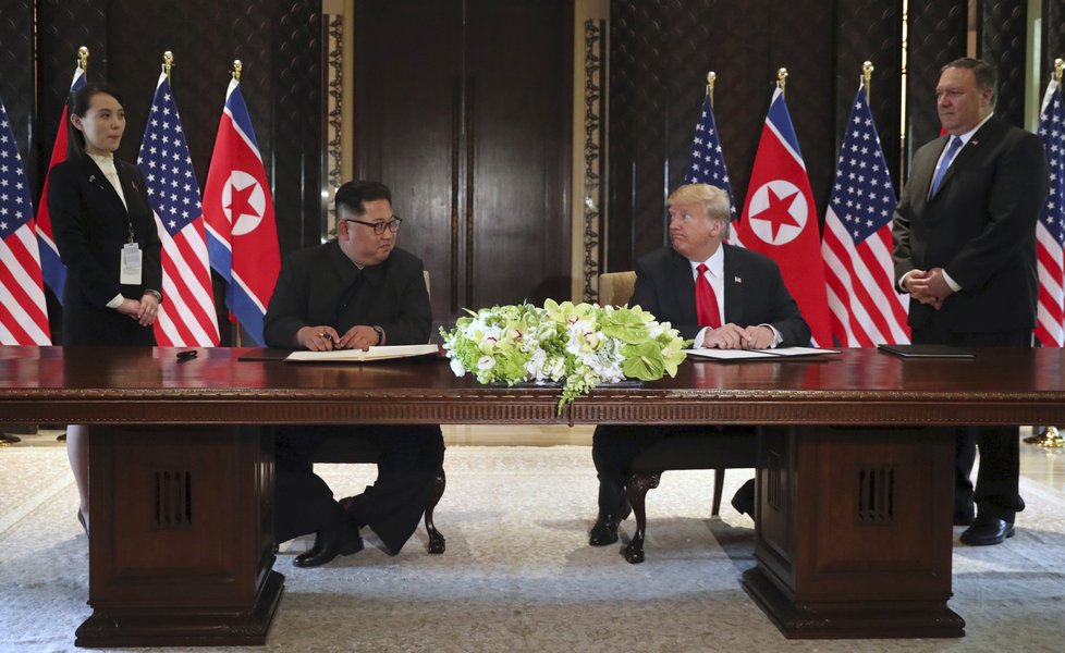 Kim Čong-unovi během podpisu smlouvy asistoval jeho mladší sestra Kim Jo-čong. Trumpovi ministr zahraničí Mike Pompeo.