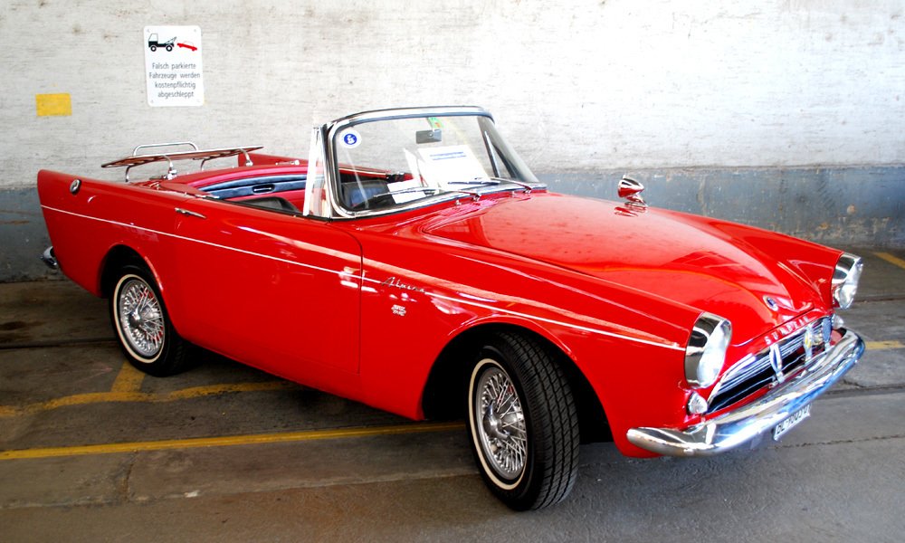 Sunbeam Alpine Series III (1963–64) ve verzi ST se skládací plátěnou střechou uloženou za zadním nouzovým sedadlem. Nosič na zádi sloužil k převozu zavazadel.