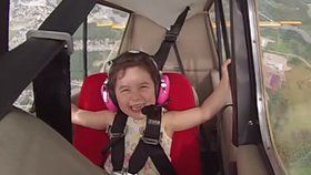 Holčička má záchvat smíchu během akrobatického letu.