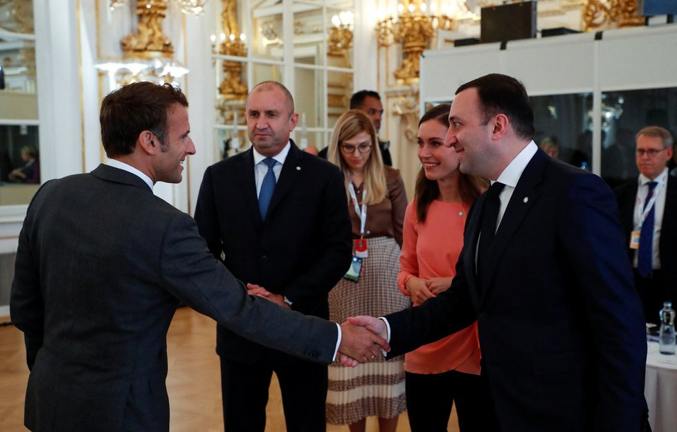 Supersummit na Pražském hradě: Emmanuel Macron se zdraví s hosty summitu, vpravo gruzínský premiér Irakli Garibašvili, vedle něj stojí finská premiérka Sanna Marinová (6. 10. 2022).