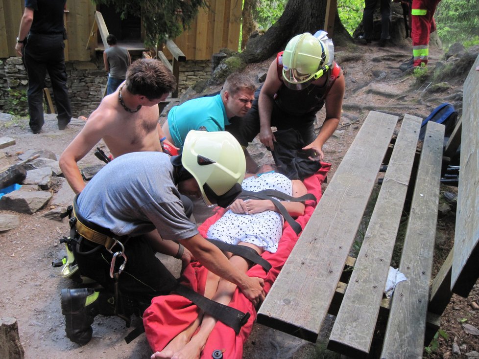 Záchranáři připravují těžce zraněnou ženu na převoz do nemocnice.
