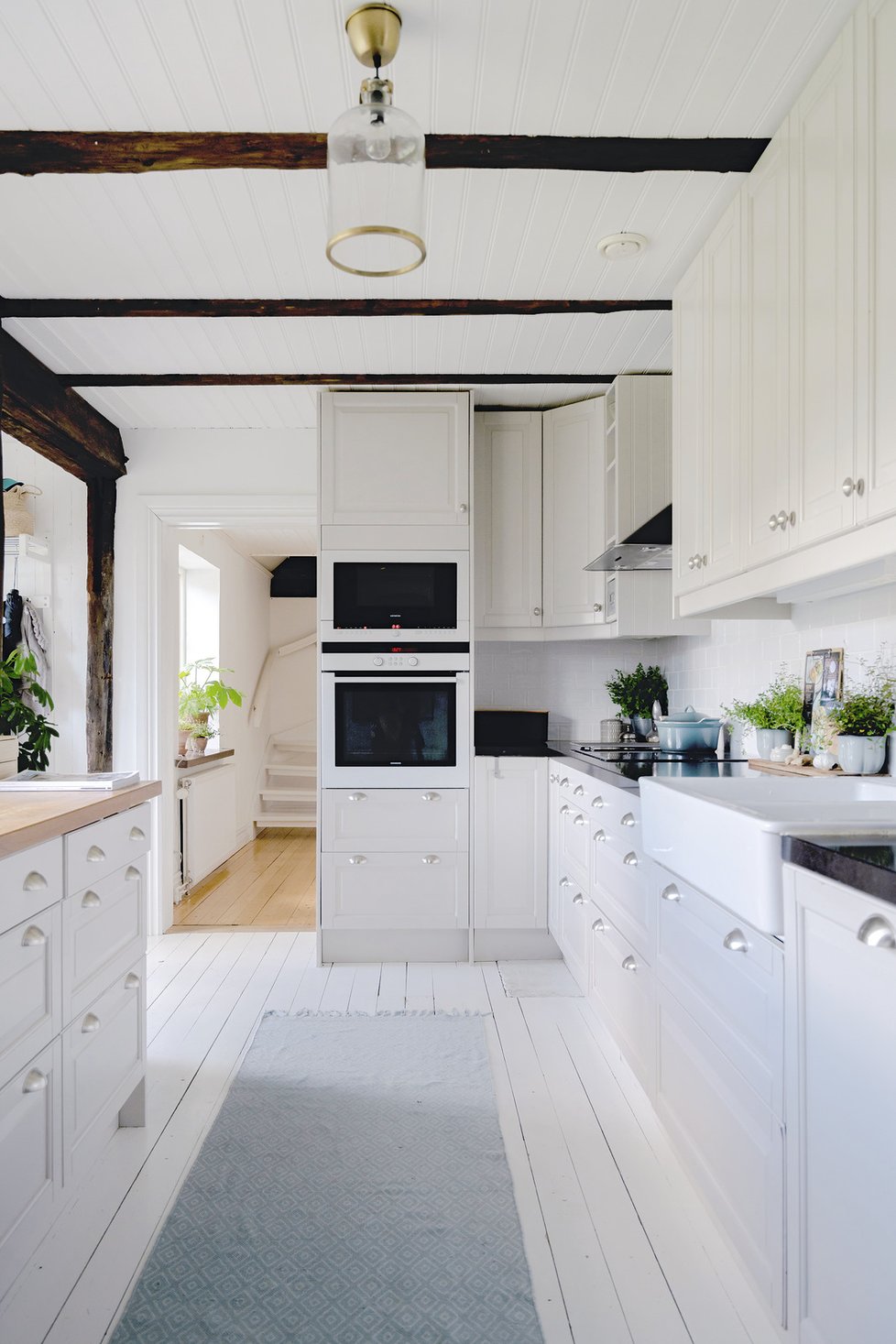 Bílá kuchyň na míru je dobře  prostorově  řešená a stylově  ladí se zbytkem  domu.