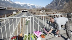 Muž pokládá květiny na uctění památky zesnulých při tragické nehodě autobusu ve švýcarském tunelu