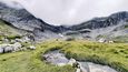 Po prudkém výstupu do sedla Bärentritt se nám otevírají panoramatické výhledy a horská pastvina nabízí chvilku odpočinku. Za necelou hodinu v sedle Furggele zažíváme prudký vítr a déšť.
