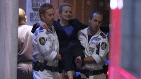 Záchranáři nesou zraněnou ženu z kavárny ze Sydney