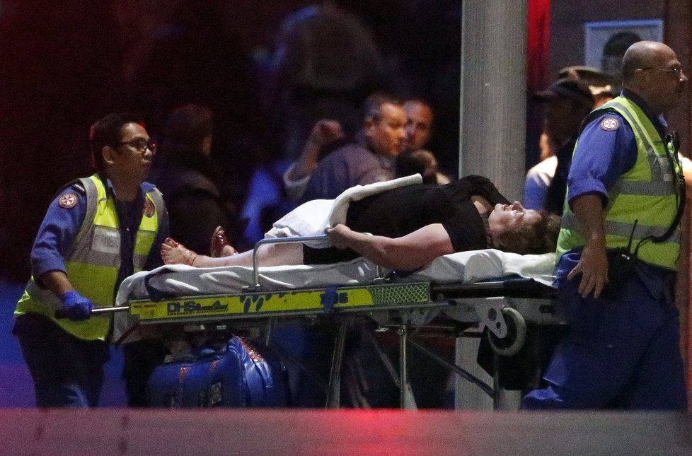 Záchranáři odvážejí zraněnou ženu z kavárny v Sydney