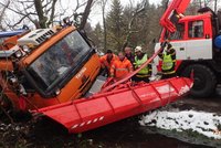 Sypač měl pomoci řidičům na zasněžené silnici, sám potřeboval vytáhnout: Uvízl totiž v bahně