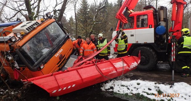 Sypač měl pomoci řidičům na zasněžené silnici, sám potřeboval vytáhnout: Uvízl totiž v bahně