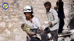 Syrský dobrovolník nese zraněné dítě.