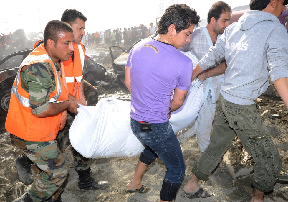 Záchranáři odnáší zbytky těl z místa výbuchu