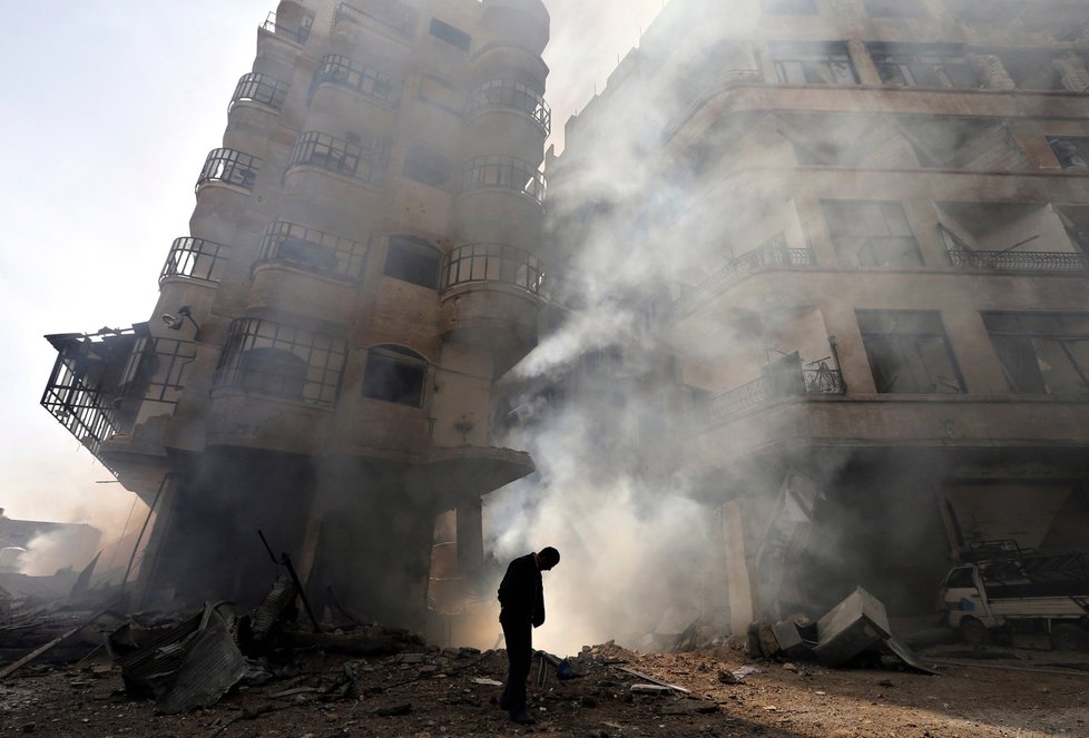 Syrský civilista před hořícím domem nedaleko Damašku