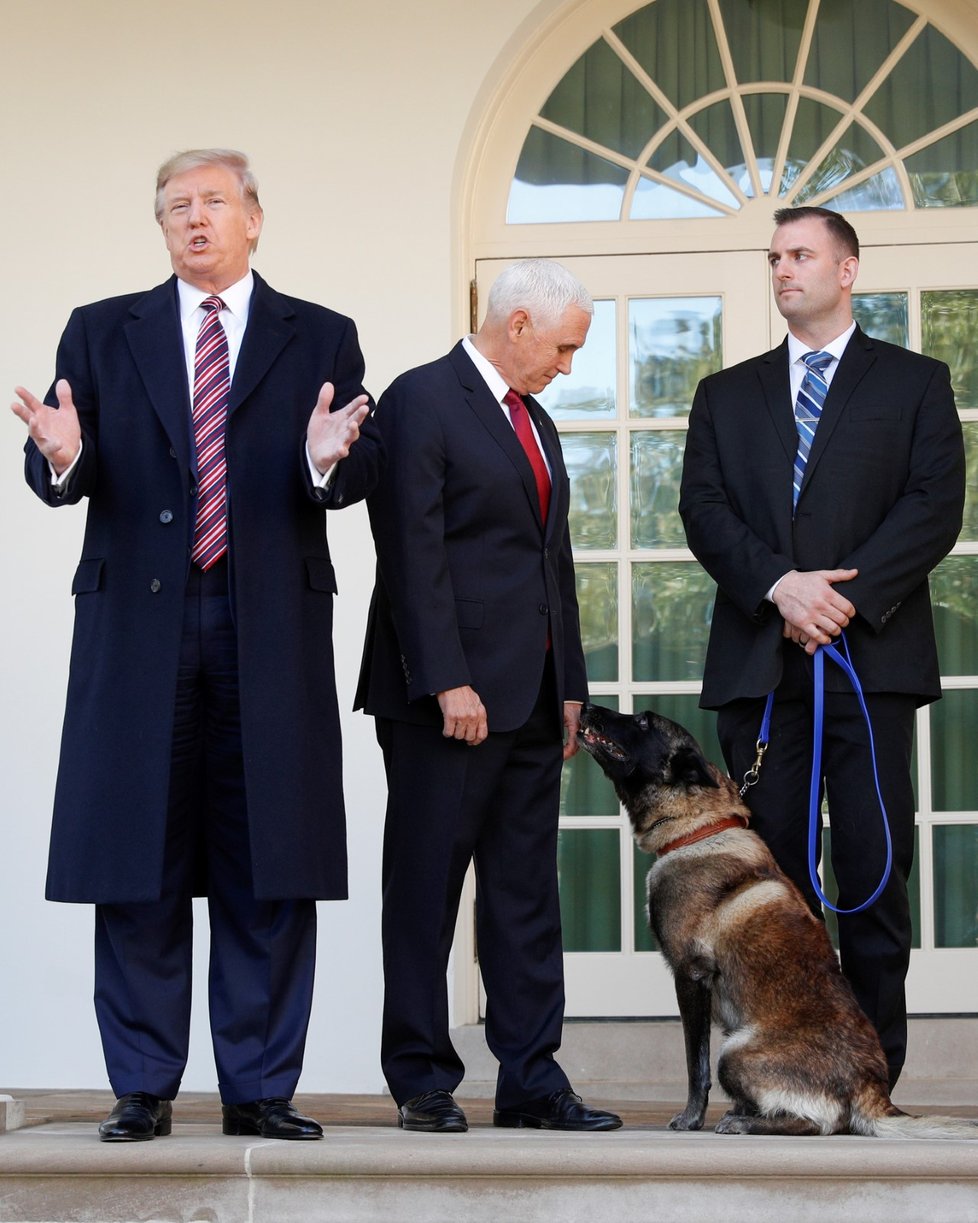 U.S. President Donald Trump speaks to the news media next to Vice President Mike Pence and Conan, the U.S. military dog that participated in and was injured in the U.S. raid in Syria that killed ISIS leader Abu Bakr al, Baghdadi