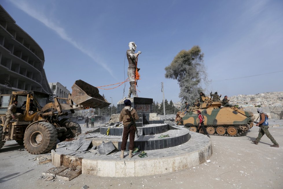Vojáci Svobodné syrské armády strhávají kurdskou sochu v centru Afrínu