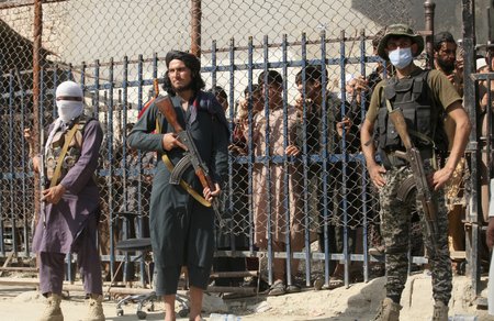 Tálibánští vojáci a pákistánský voják na hraničním přechodu Afghánistánu
