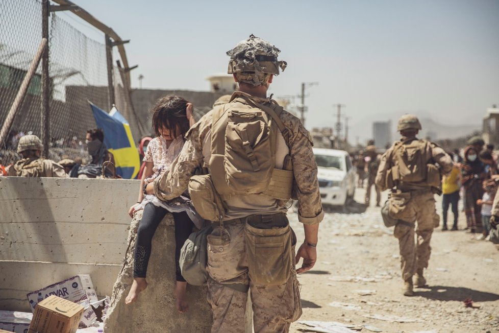 Američtí vojáci zachraňují děti v okolí kábulského letiště.