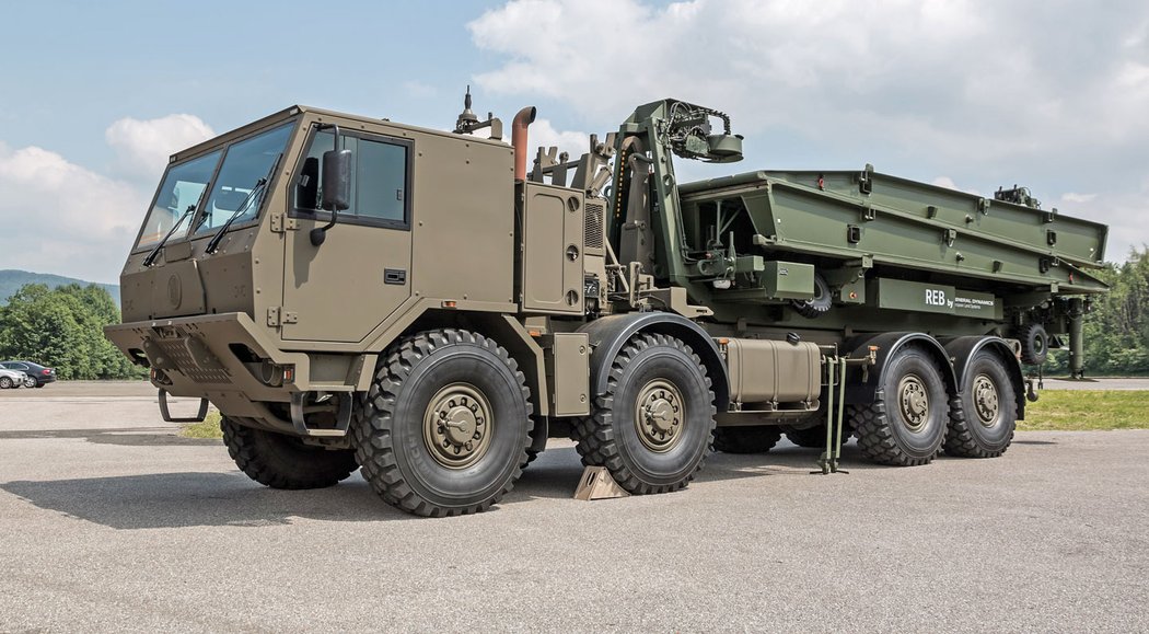 Hákový nakládač kontejnerů 20 stop na podvozku T 815-7 8x8 jako nosič mostní soupravy společnosti General Dynamics