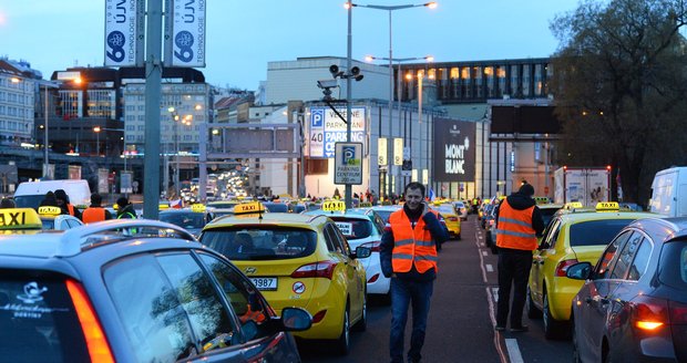 Až 300 vozidel taxi blokuje v pondělí magistrálu před Hlavním nádražím v Praze.