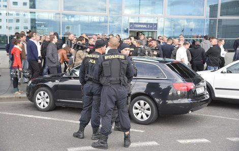 Taxikáře na letišti v Praze krotí policisté. Na vozy řidičů Uberu letí samolepky s nápisem Ilegal Transport.