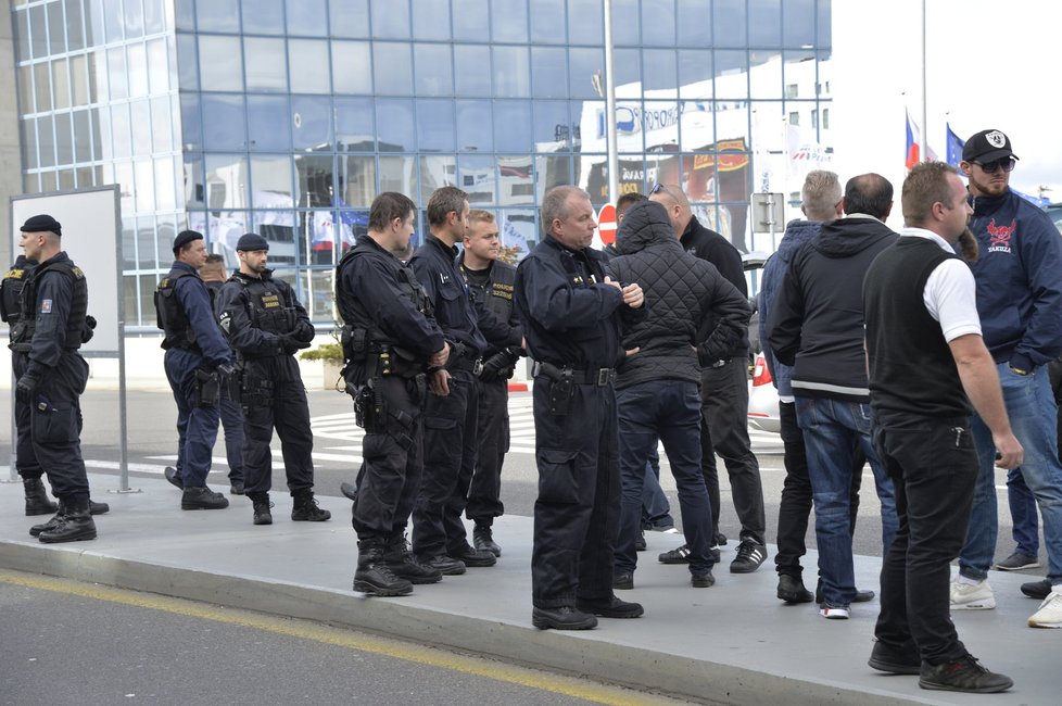 Taxikáře na letišti v Praze krotí policisté. Na vozy řidičů Uberu letí samolepky s nápisem Ilegal Transport.