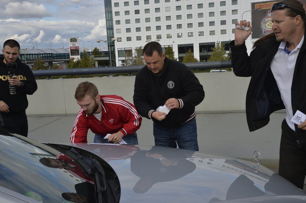 Taxikáře na letišti v Praze krotí policisté. Na vozy řidičů Uberu lepí samolepky s nápisem Ilegal Transport.