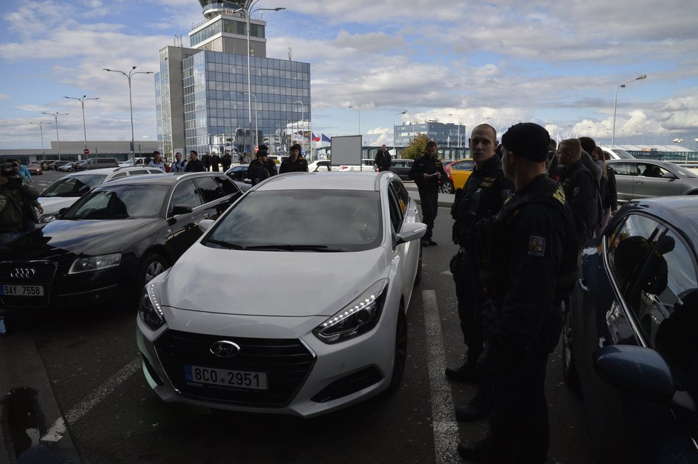 Taxikáře na letišti v Praze krotí policisté. Na vozy řidičů Uberu letí samolepky s nápisem Ilegal Transport.