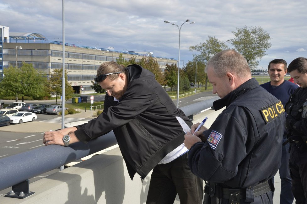 Taxikáře na letišti v Praze krotí policisté. Na vozy řidičů Uberu lepí samolepky s nápisem Ilegal Transport.