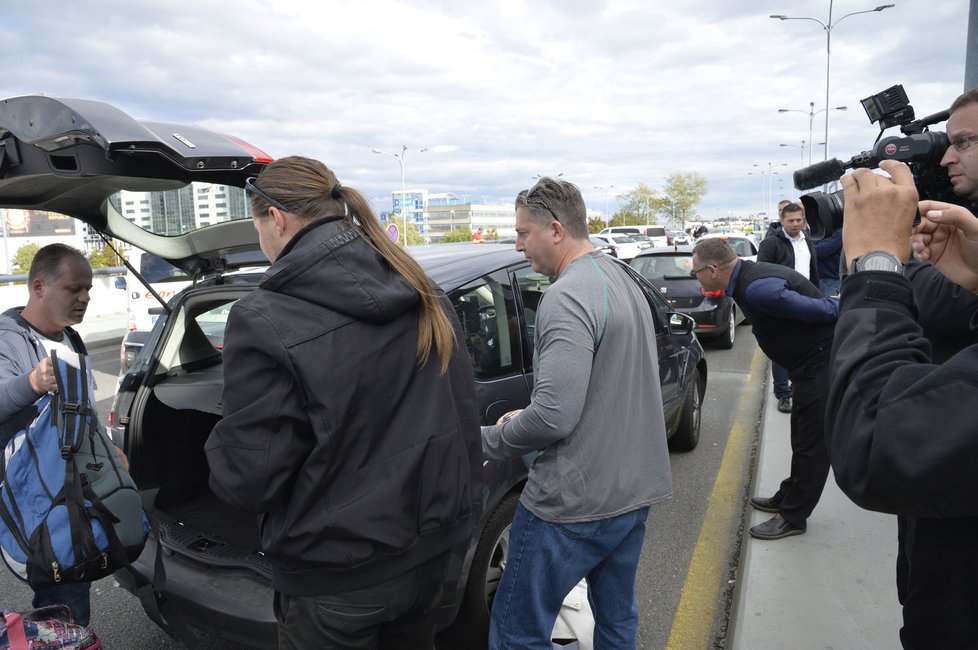 Taxikáře na letišti v Praze krotí policisté. Na vozy řidičů Uberu letí samolepky s nápisem Ilegal Transport.