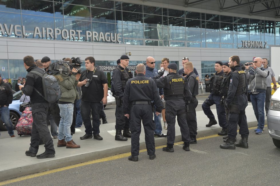 Taxikáře na letišti v Praze krotí policisté. Na vozy řidičů Uberu letí samolepky s nápisem Ilegal Transport.