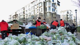 Tchien-ťin: Dobrovolníci distribuují zeleninu pro lidi v lockdownu.