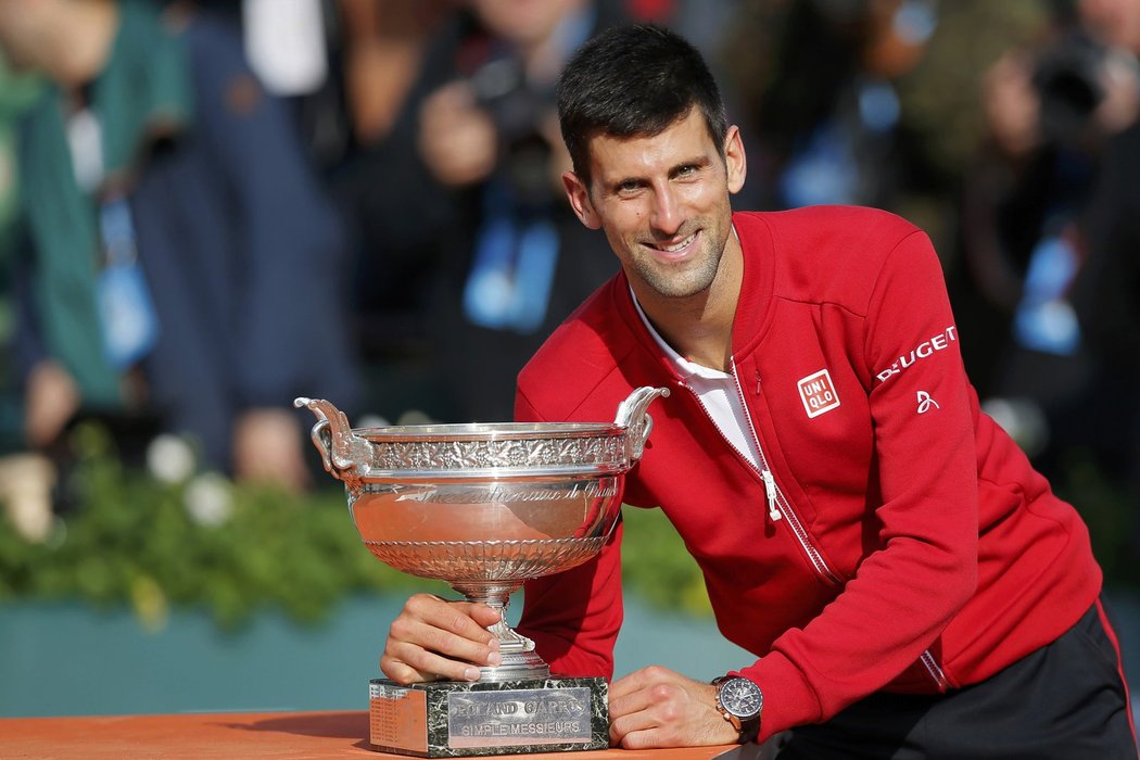 Novak Djokovič pózuje s pohárem za triumf na Roland Garros