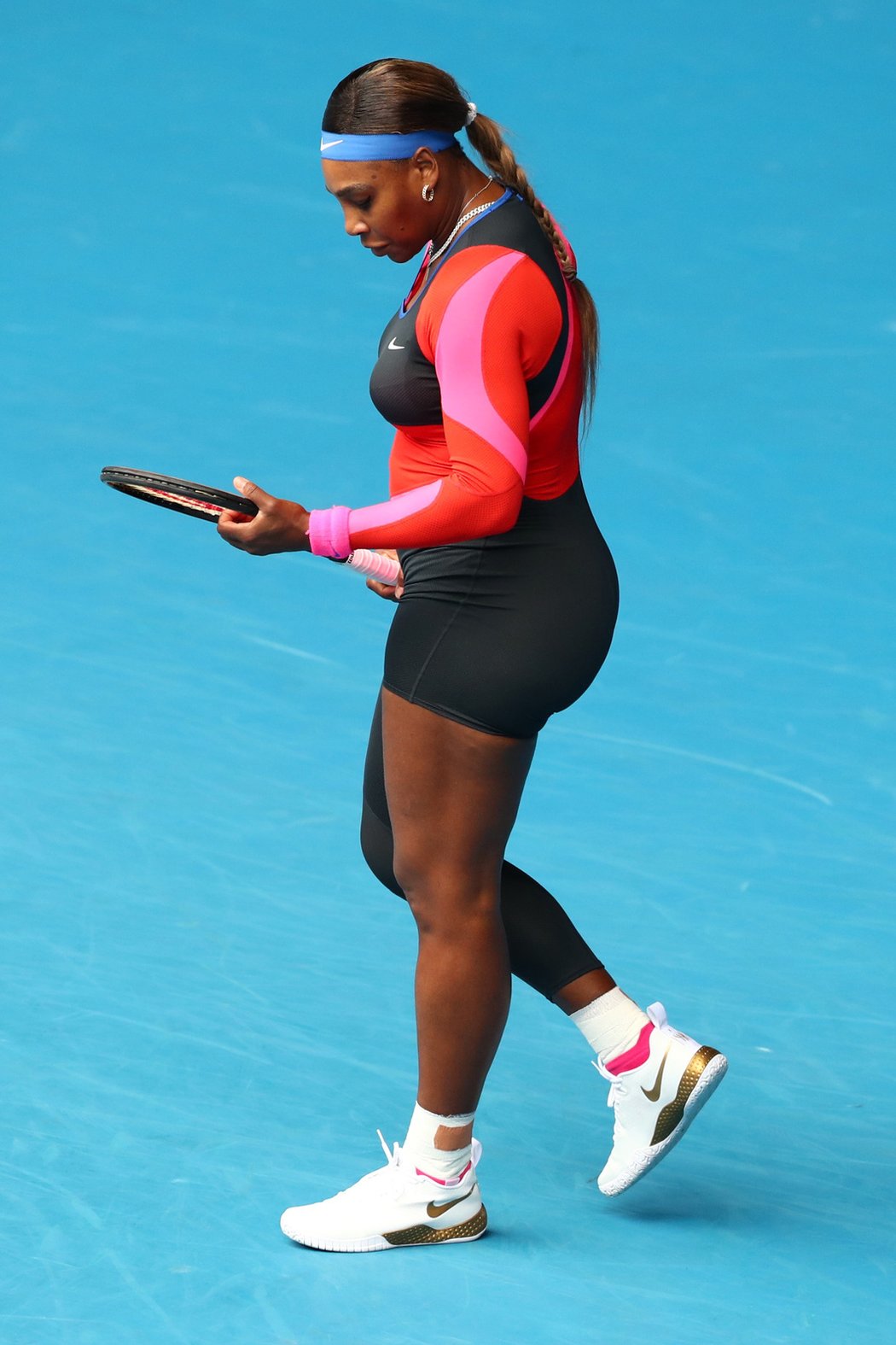 Serena Williamsová v černo-červeno-růžovém elastickém trikotu s nestejně dlouhými nohavicemi na Australian Open