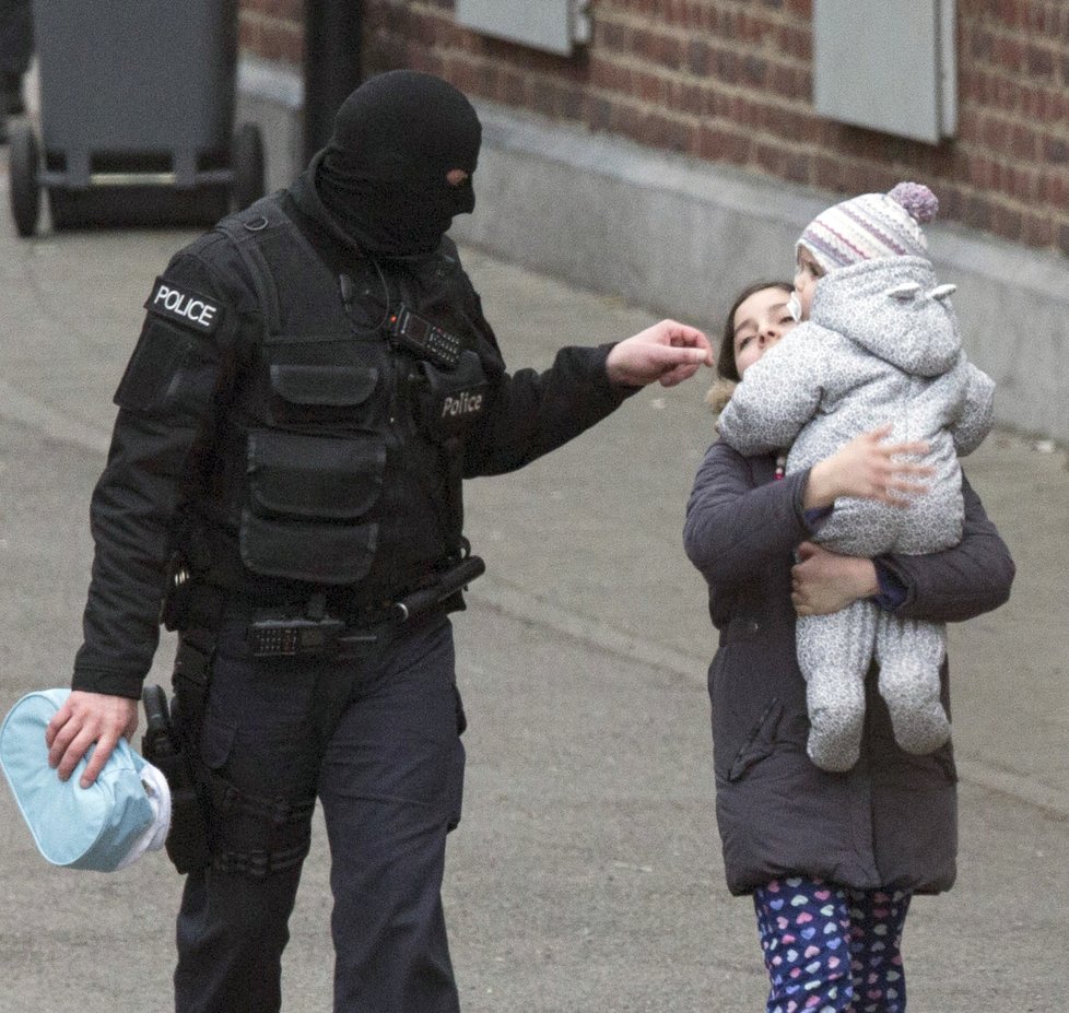 Policista dává pokyny mamince s dítětem.