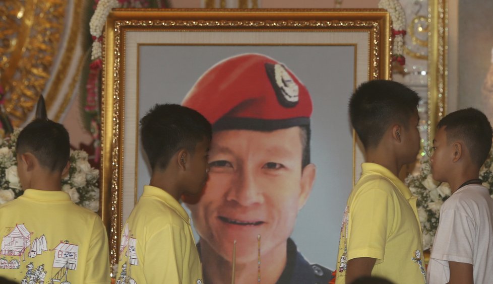 Thajští chlapci a jejich trenér se po propuštění z nemocnice účastnili obřadu za zemřelého potápěče.