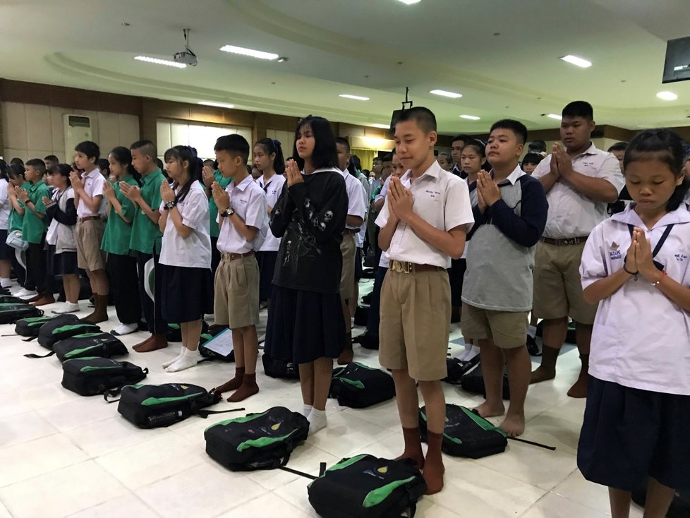 Modlící se studenti ve škole v Maesaiprasitsart v Thajsku za uvězněné fotbalisty v jeskyni. V této škole studuje šest z dvanácti zachráněných chlapců..