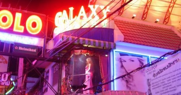 Walking Street v letovisku Pattaya. A dívka tančící v prosklené buňce. 
