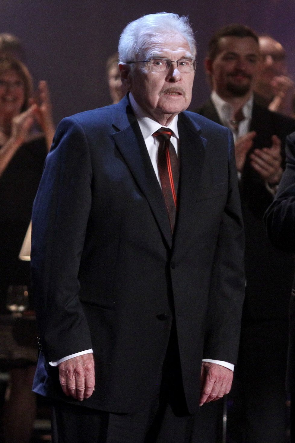 Legendární herec Luděk Munzar přebíral celoživotní cenu za herecké mistrovství v tmavém konvenčním obleku, do nějž uvázal patřičnou kravatu.