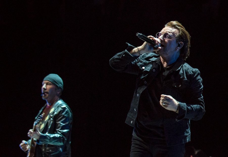 Klasický pohled na kapelu U2, zpěvák Bono a při něm kytarista the Edge. Jeho jmění se odhaduje na 340 milionů dolarů.