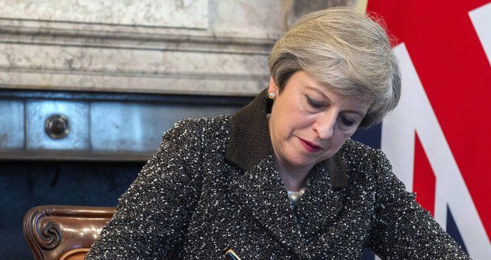 Britská premiérka Theresa May připojuje svůj podpis. Teď je brexit oficiální.