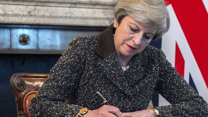 Britská premiérka Theresa May připojuje svůj podpis. Teď je brexit oficiální.