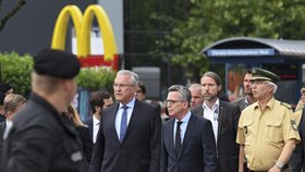 Německý ministr vnitra Thomas de Maizière před McDonaldem, kde došlo k útoku.