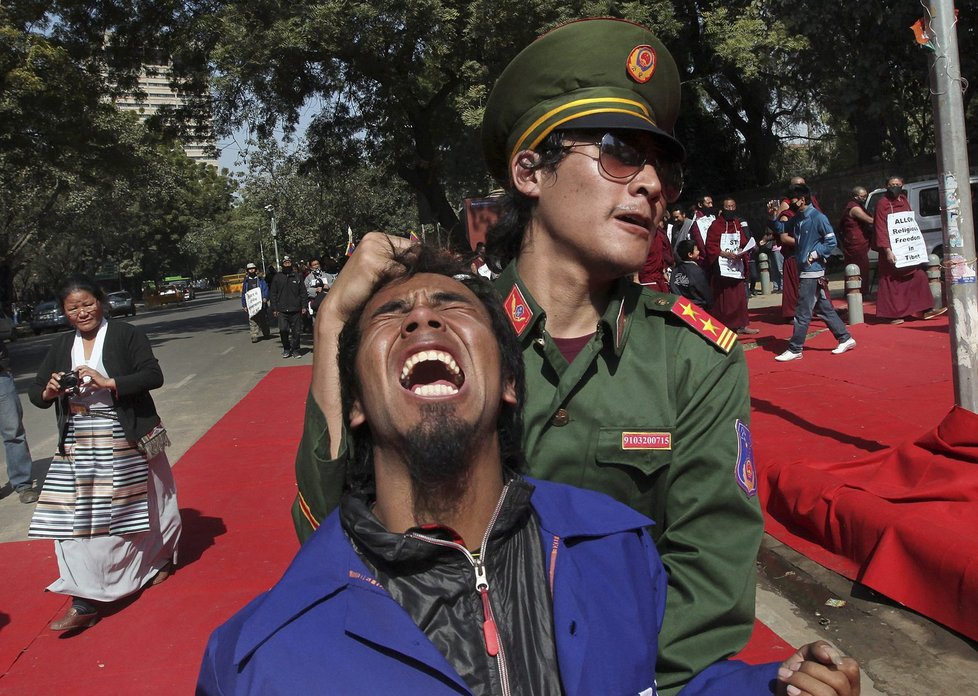 Tibetští aktivisté sehrávají při demonstraci scénku, znázorňující čínskou policejní brutalitu